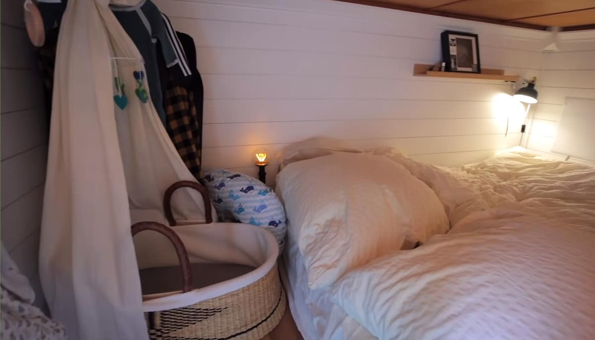 tiny home bedroom with bassinet by bed