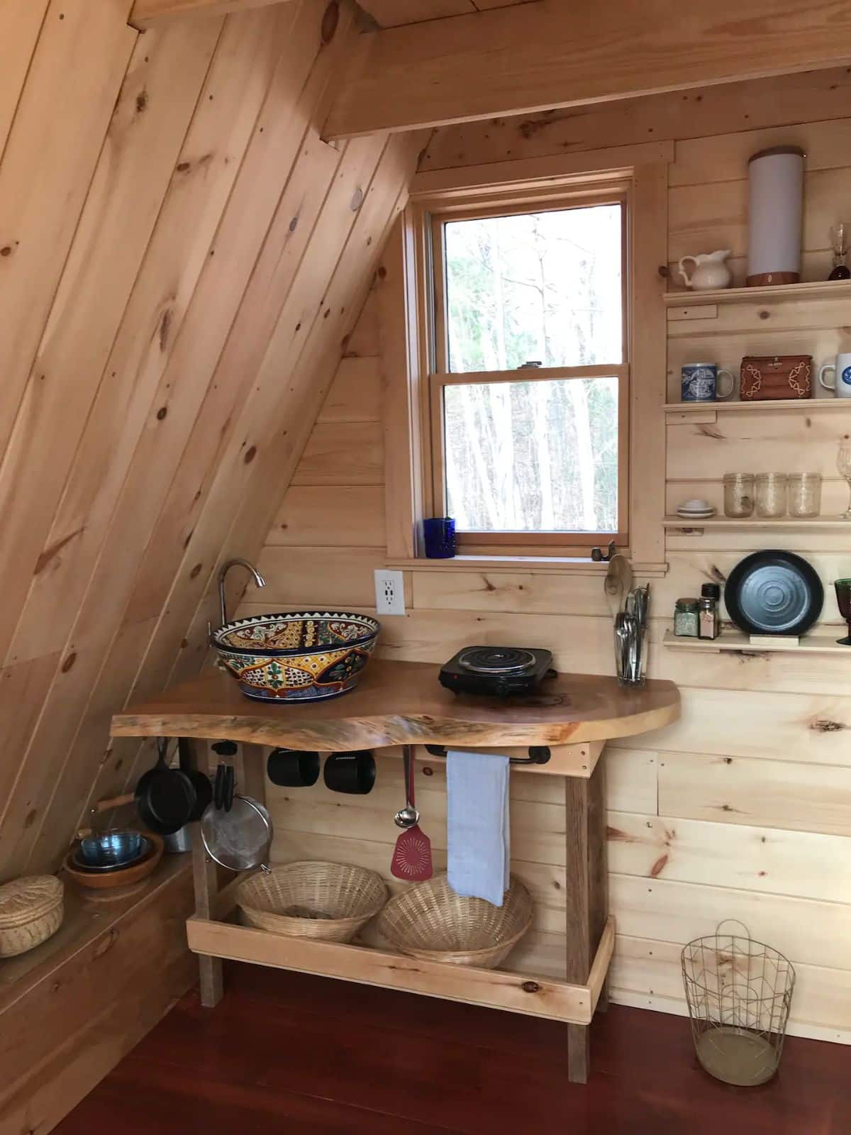 simple live edge counter with bowl sink next to hot plate in tiny cabin