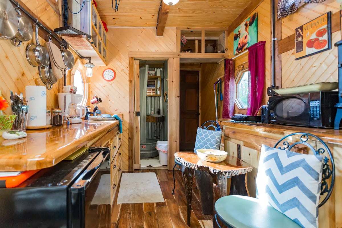 Efficient tiny home galley style kitchen with entryway and bathroom at front