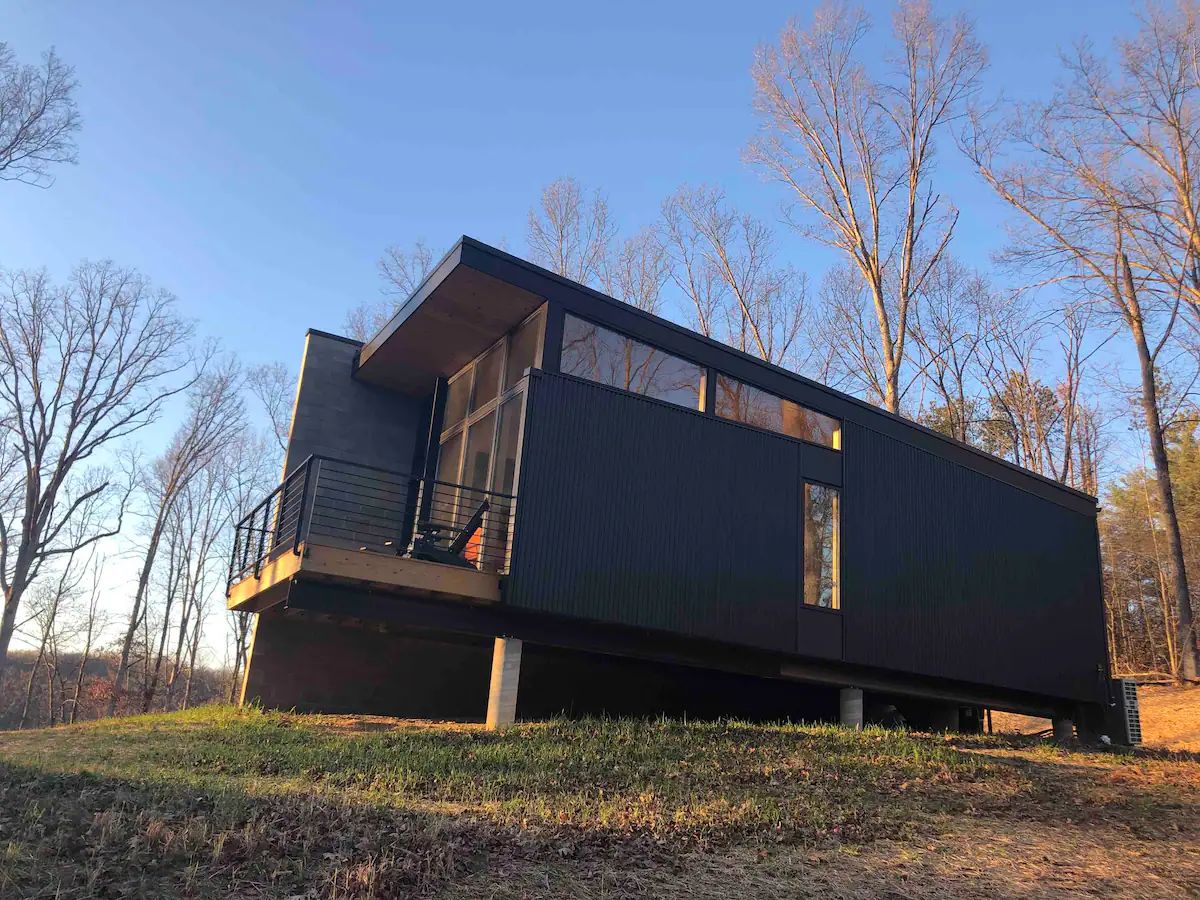 black tiny home with open porch on end