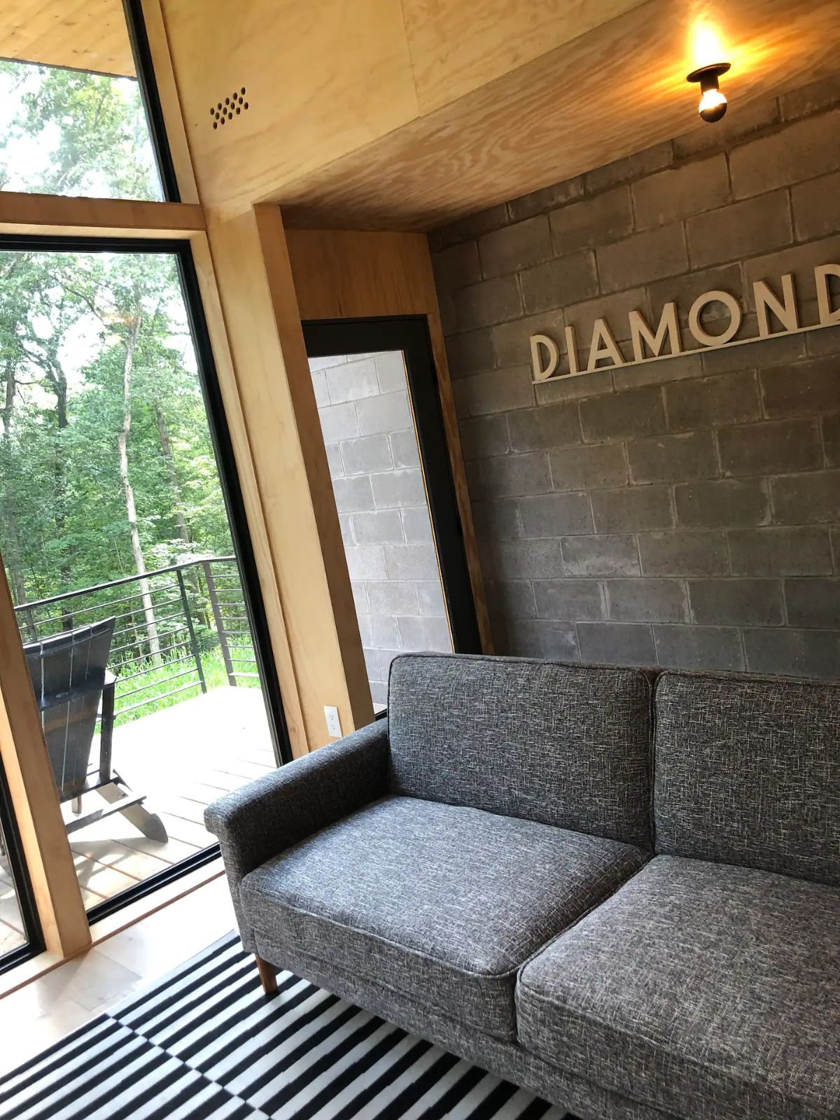 gray sofa against brick wall with diamond sign above