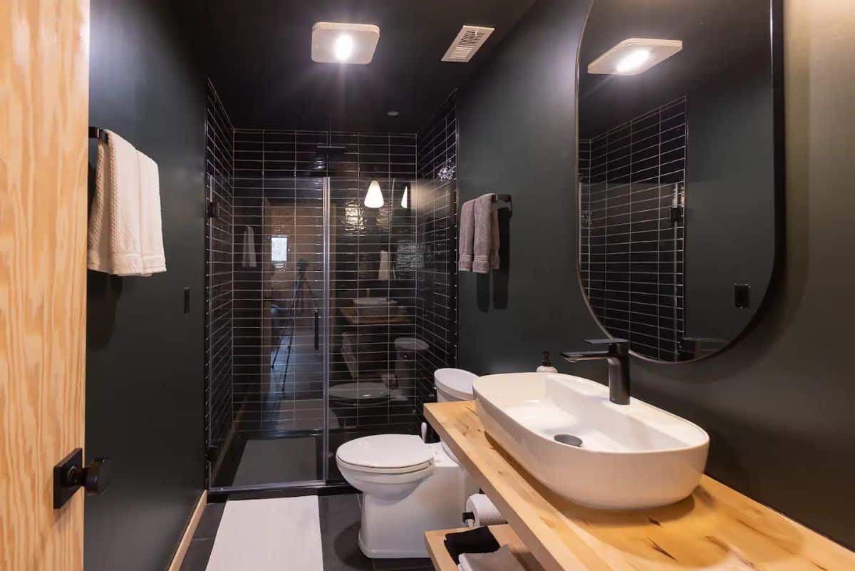 black bathroom with white toilet and sink