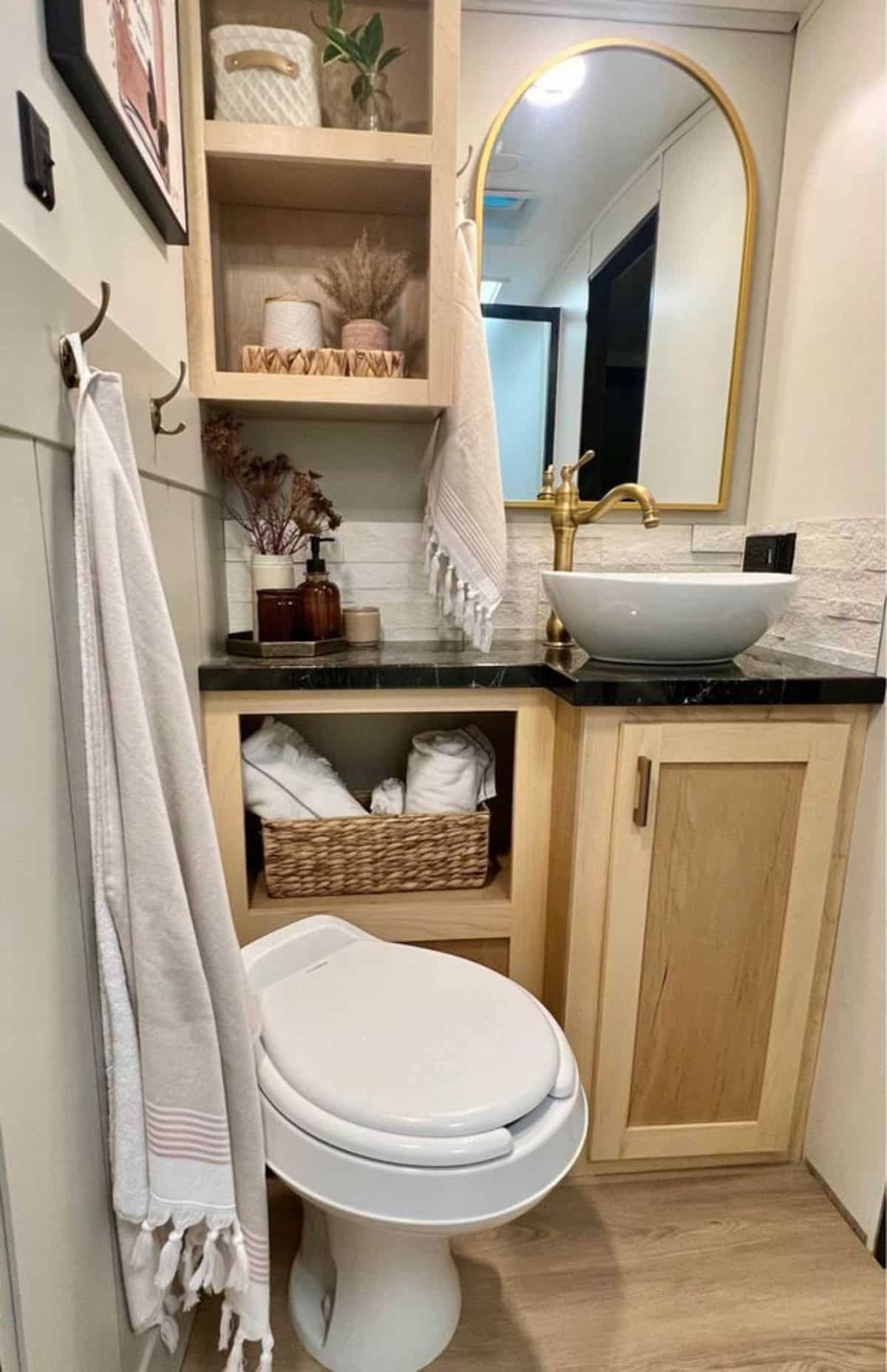 Stylish bathroom has sink with vanity & mirror and standard toilet