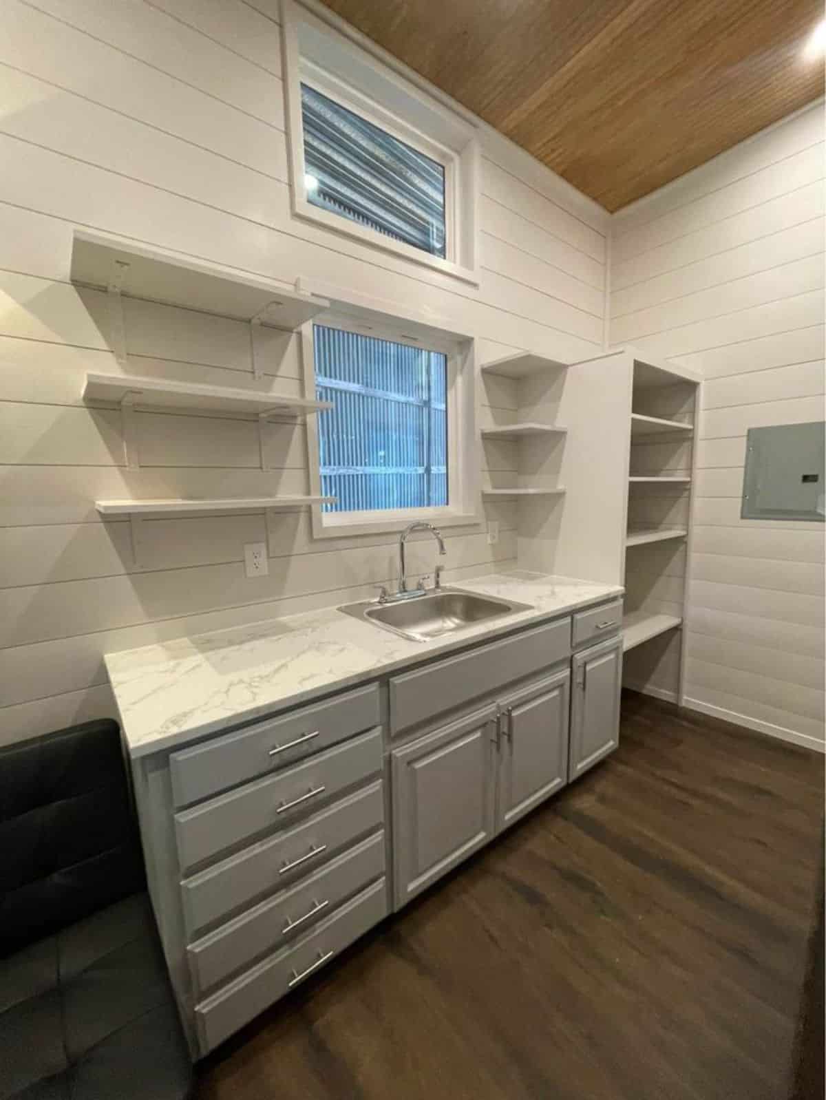 Full white themed Kitchen area of rustic 30’ tiny house