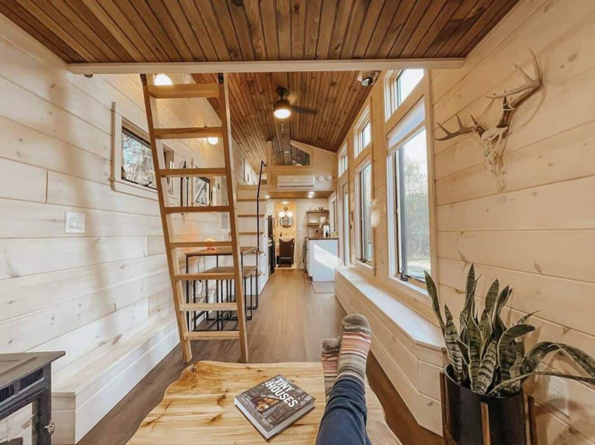 view from sofa in living space across tiny home with ladder on left