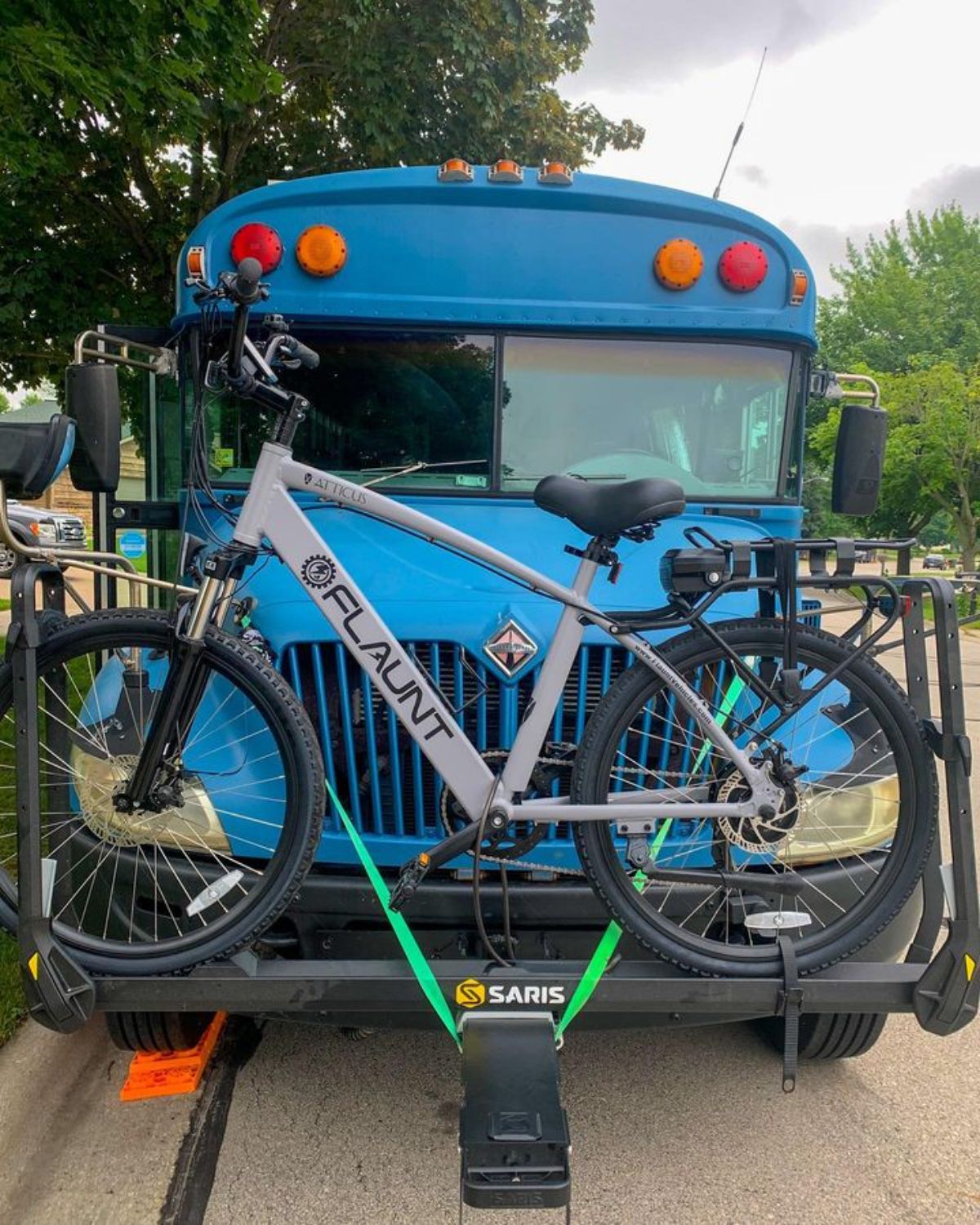 bicycle mounted on front of blue bus