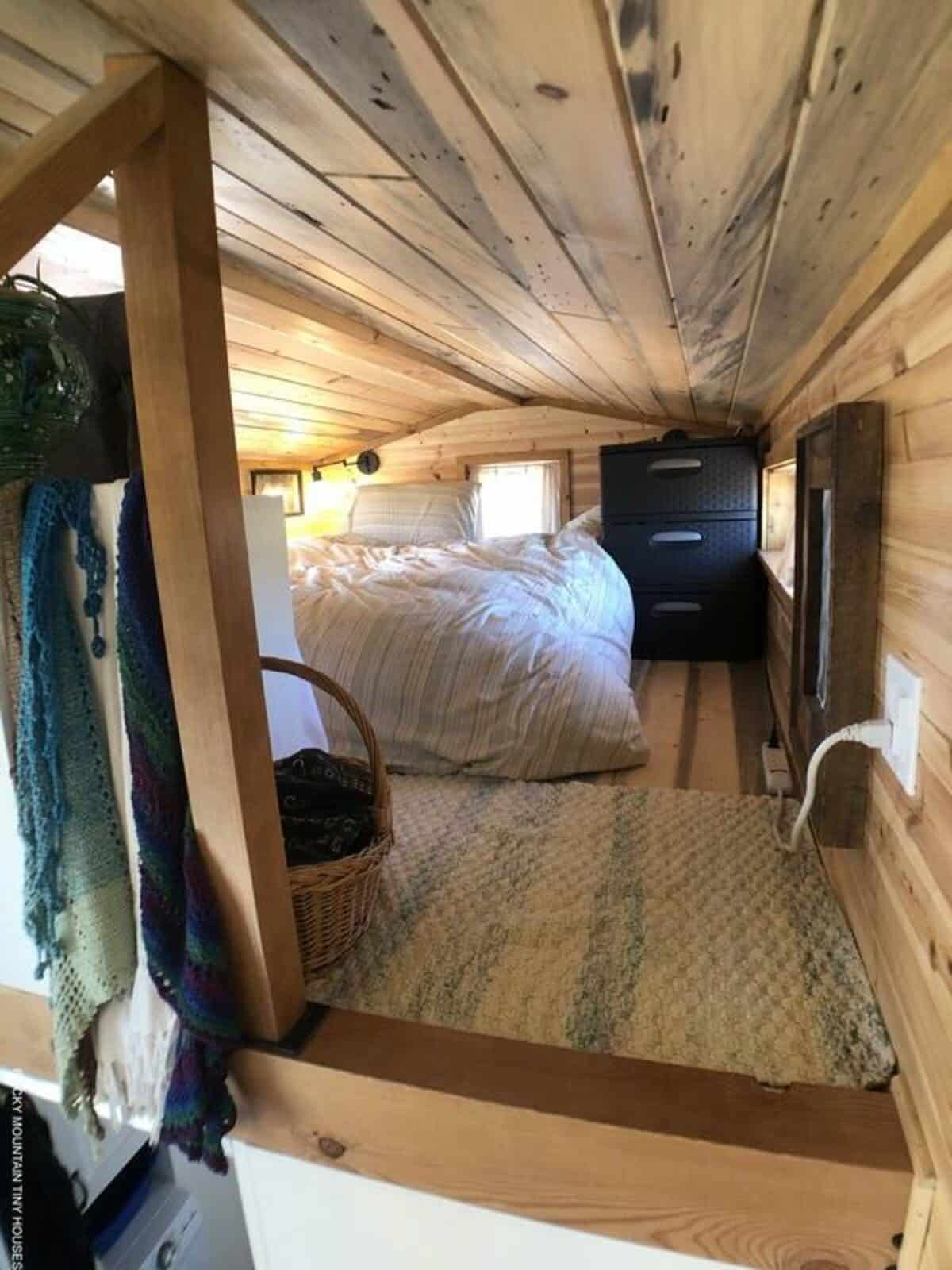 Sleeping loft with windows for natural light, comfortable bed, and cozy crawlspace loft