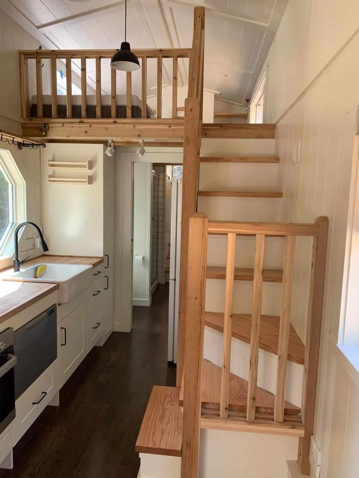 Stairs leading to the loft bedroom of spacious gooseneck tiny house