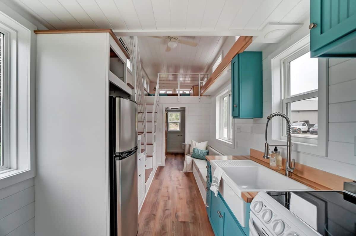 refrigerator on left with teal and white cabinets on right