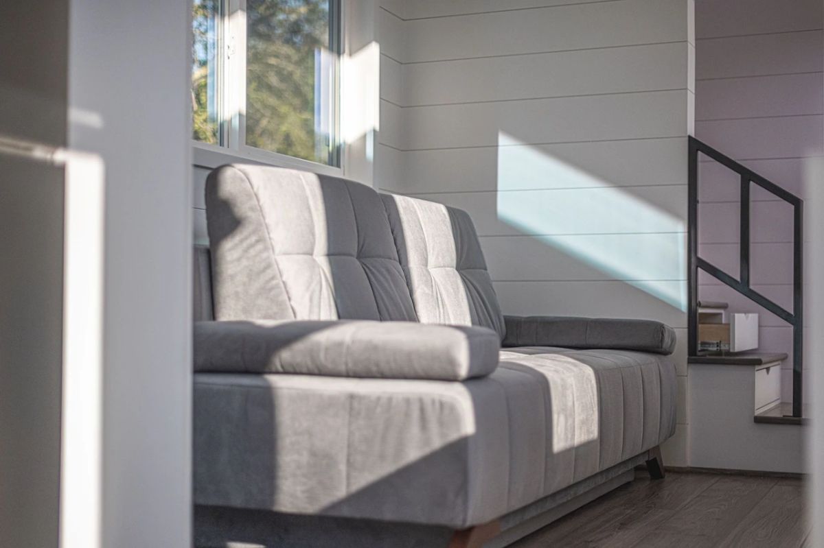 gray sofa with sunlight shining in from window in background