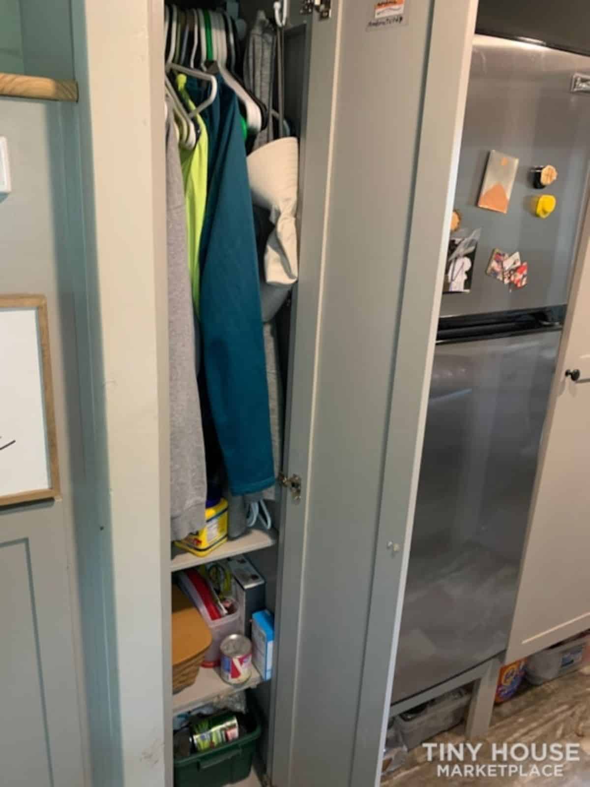 Storage cabinets besides the refrigerator under the stairs