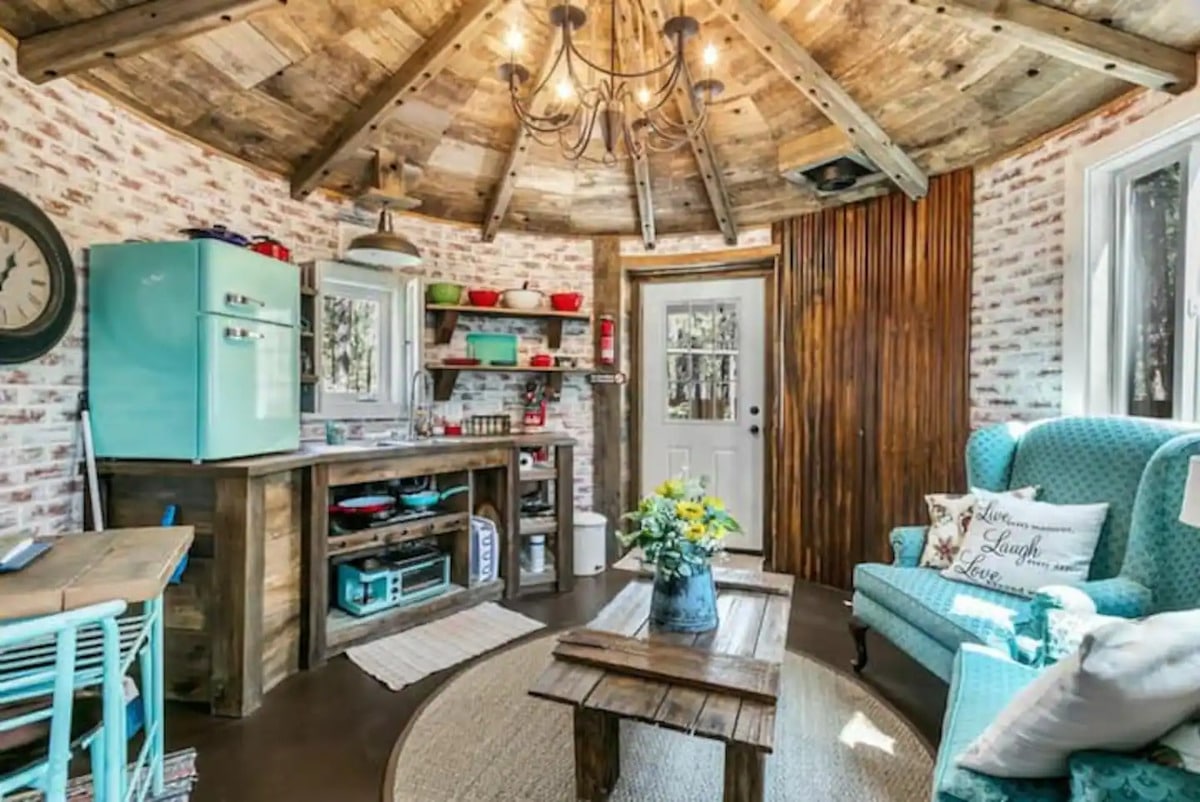 Cozy and efficient galley kitchen with rustic lower shelves and countertop, vintage looking half fridge, sink with separate overhead light, and retro style 3-in-1 breakfast station