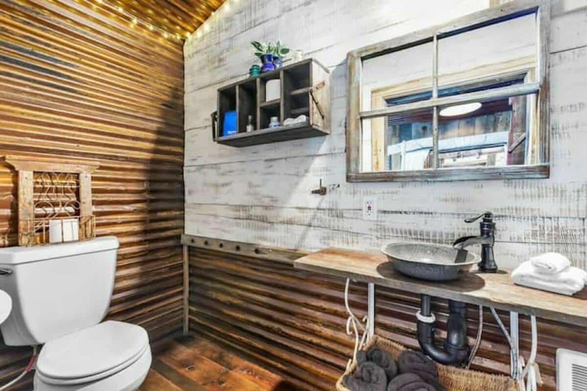 Rustic bathroom with reclaimed barn board siding, rustic rusty corrugated siding on ceiling and wall covering
