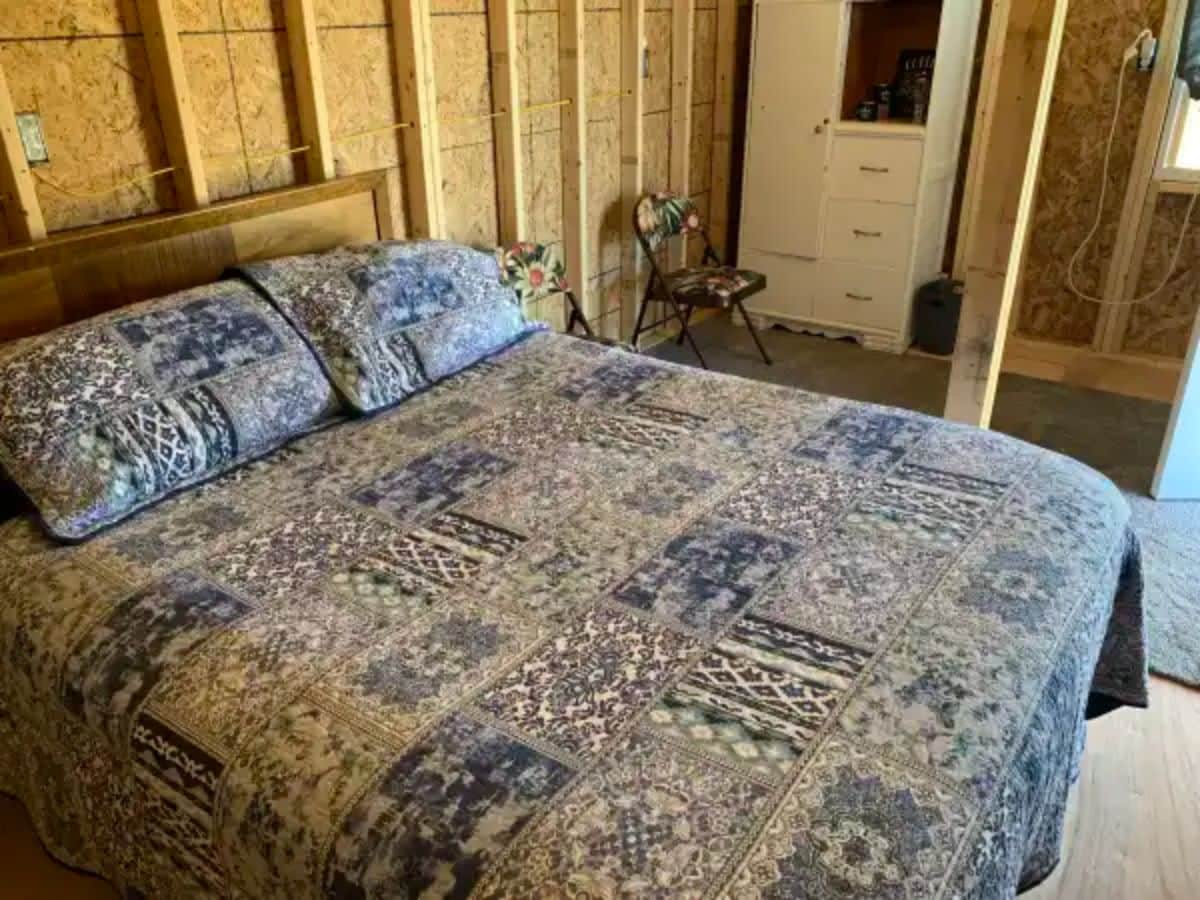 blue and white bedding in cabin with white shelf in background