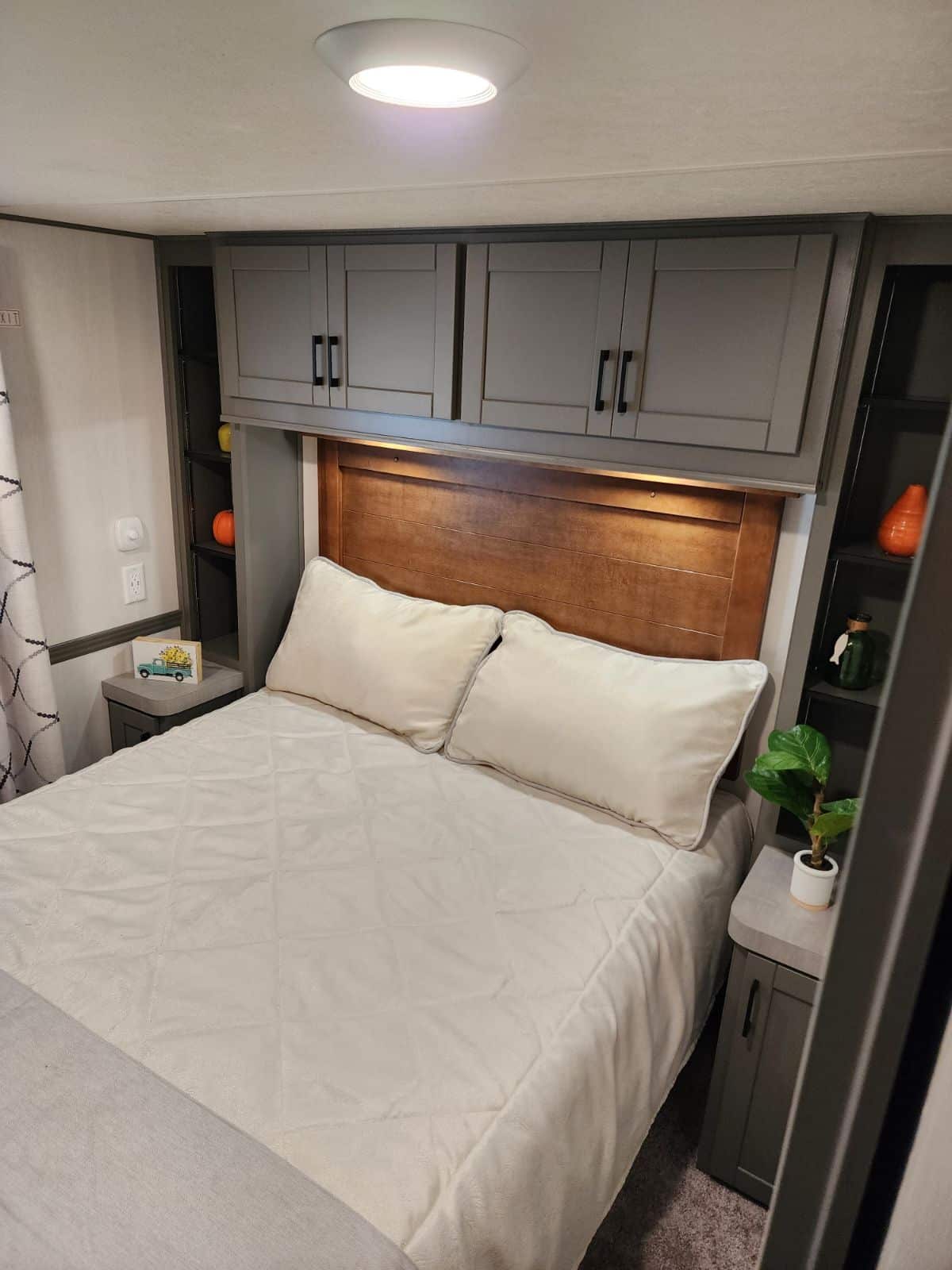 A bedroom with a king-size bed and cabinets in a tiny house.