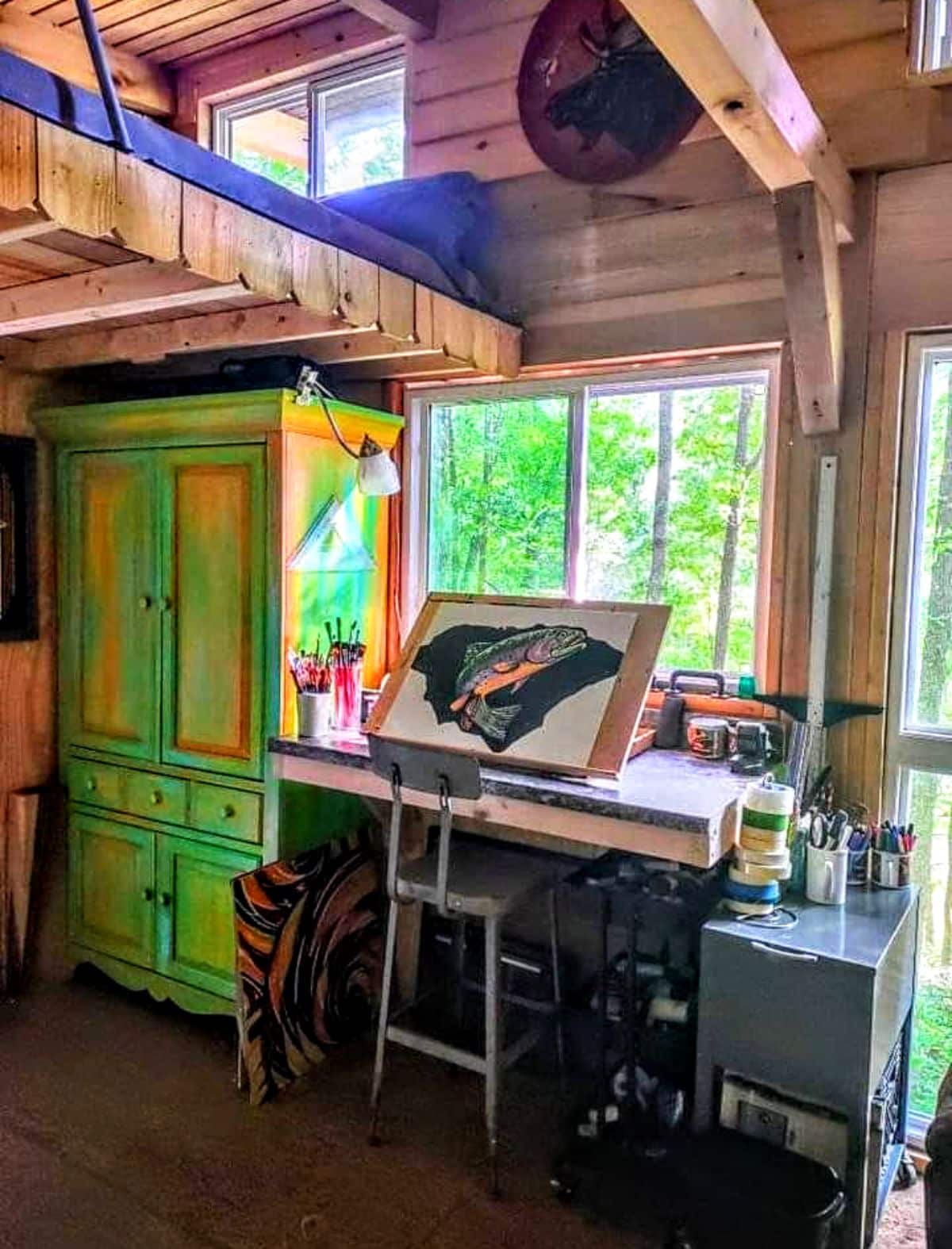 Ray’s Cabin Off-the-Grid Tiny House indoor with a furniture and a painting area.