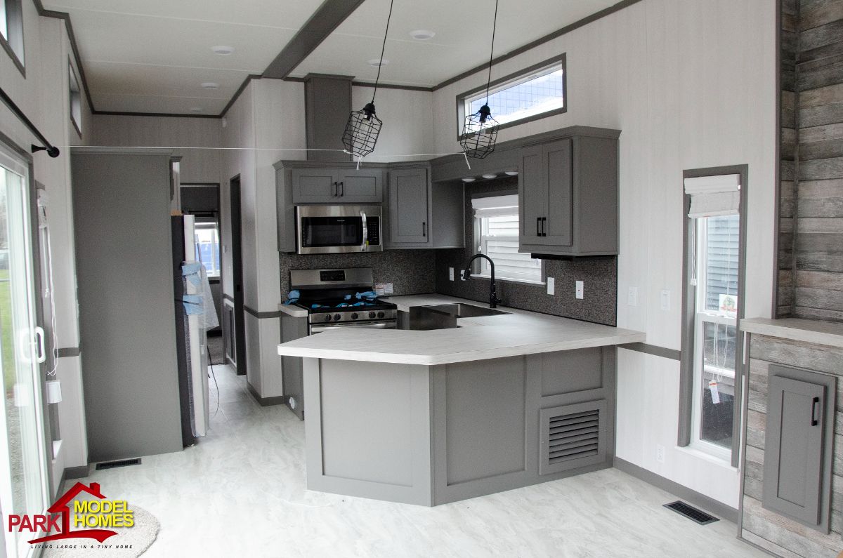 A white modern-looking tiny house with modern-looking kitchen.