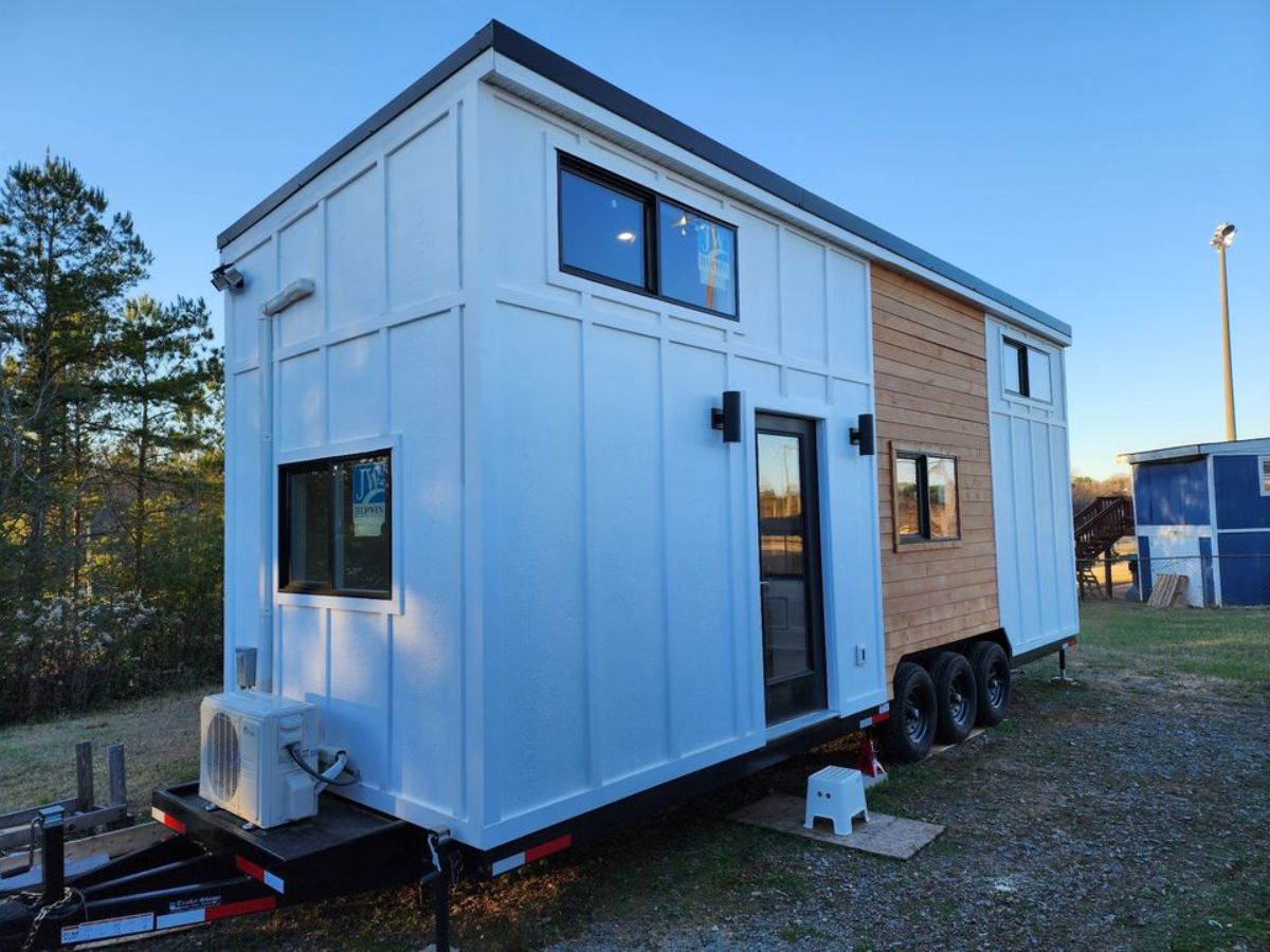 white exterior with multiple glass windows of 2 bedroom tiny home