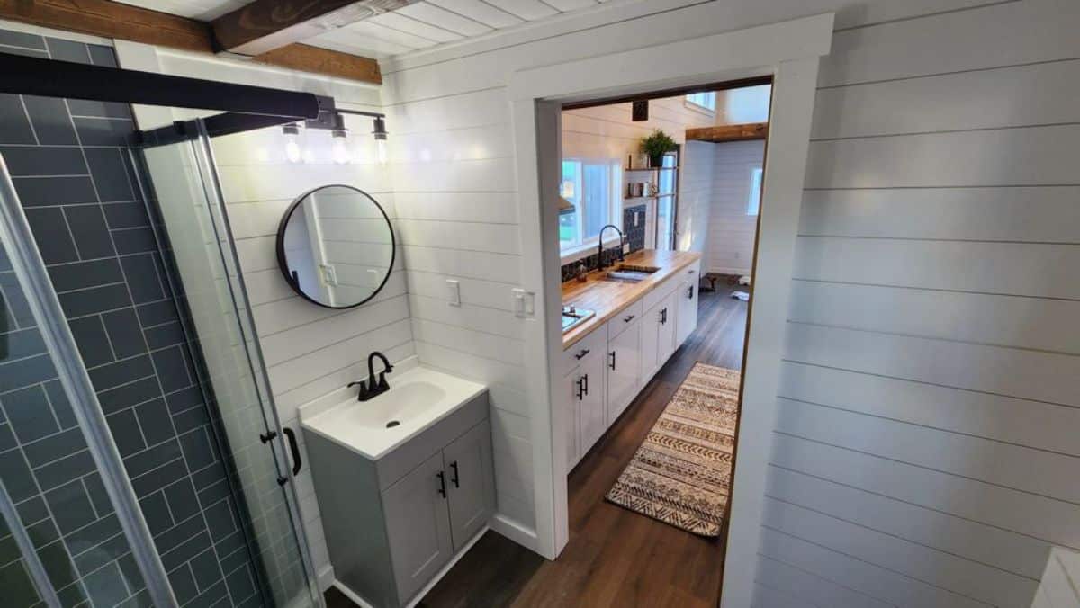 sink with vanity & mirror in bathroom of 2 bedroom tiny home