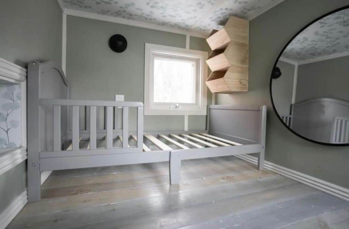 Another bedroom inside has a bed, mirror and storage racks with ample space