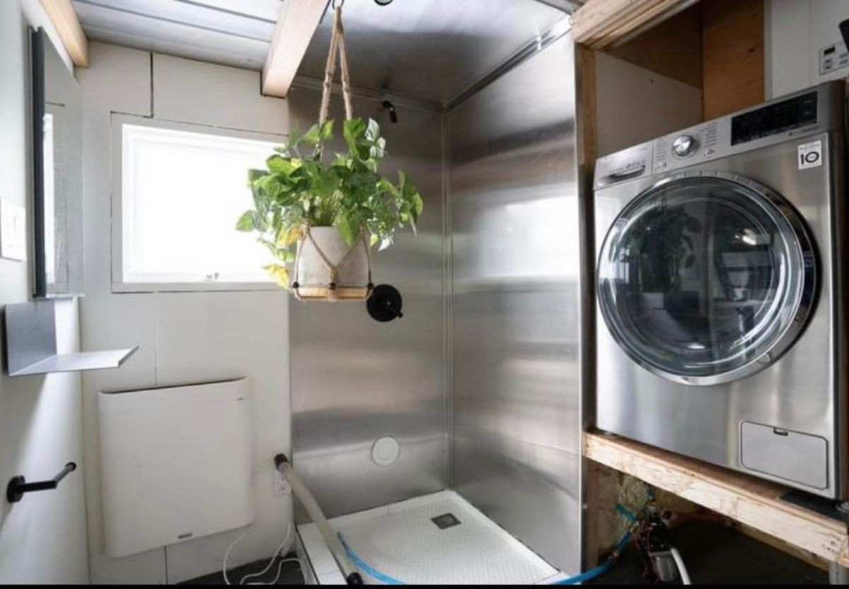 bathroom of 2 bedroom tiny house has all the standard fitting and washer dryer combo