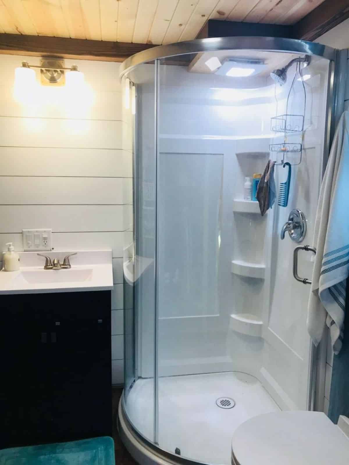 standard fittings with separate shower area with glass enclosure in bathroom of affordable 2 bedroom tiny home