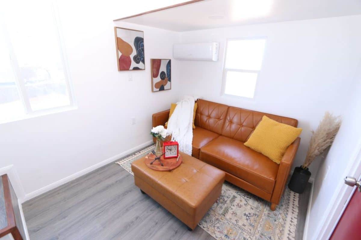 living area of the dual loft tiny house has a couch and center table