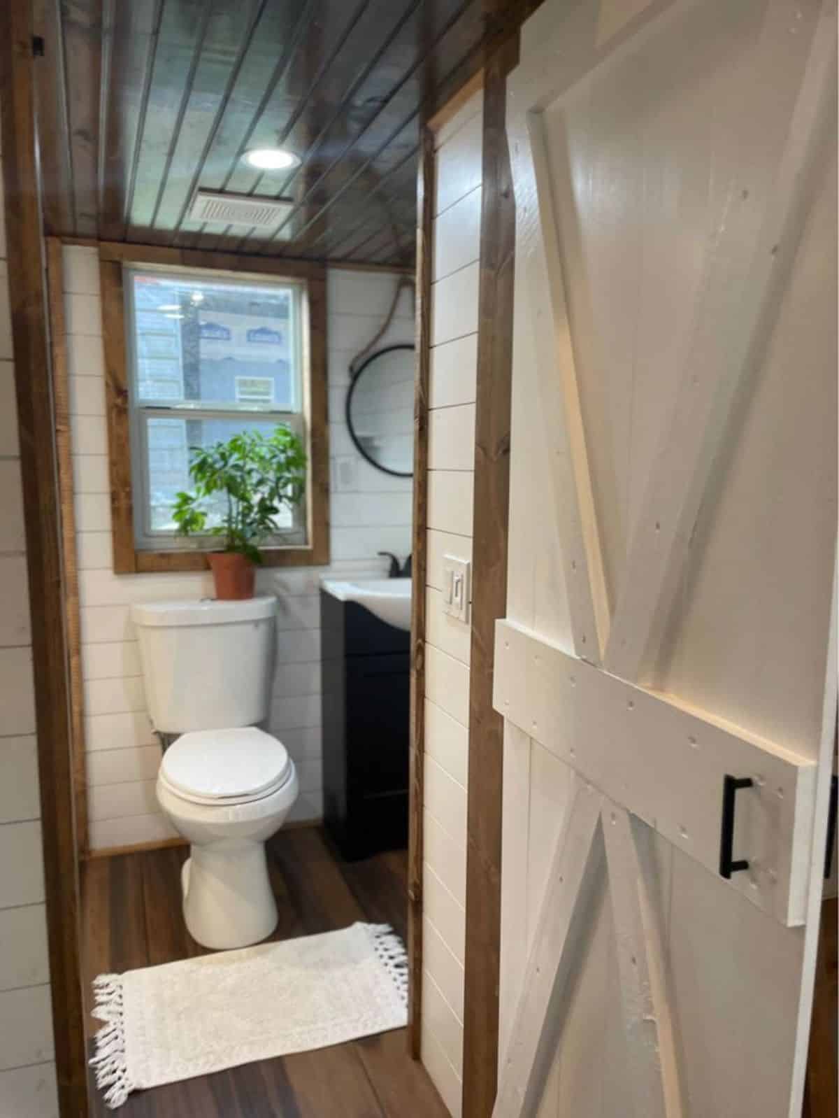 standard toilet in bathroom of 24’ tiny house on wheels