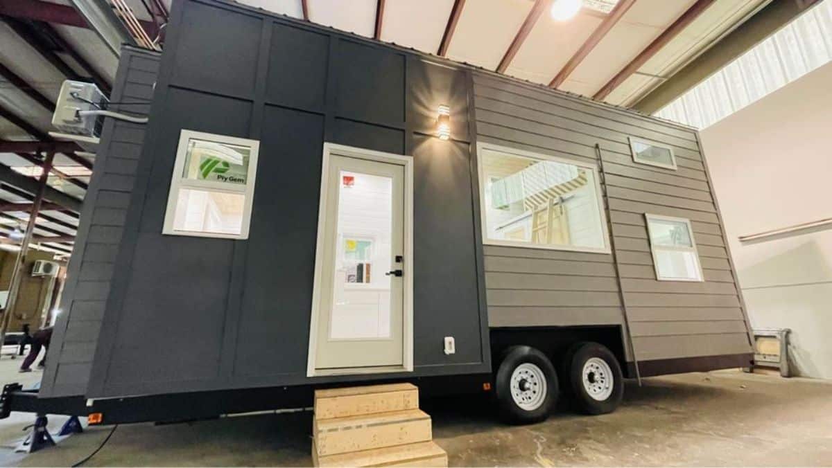 main entrance and stunning black exterior of 24’ tiny house on wheels