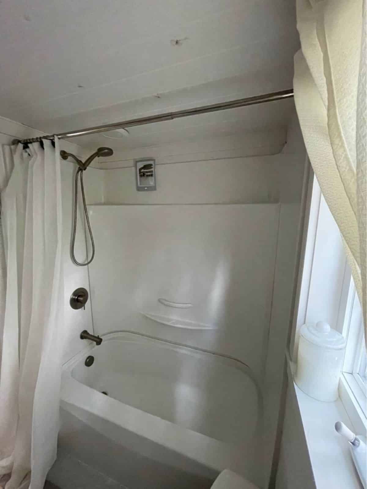 bath tub in bathroom of tiny home with lot