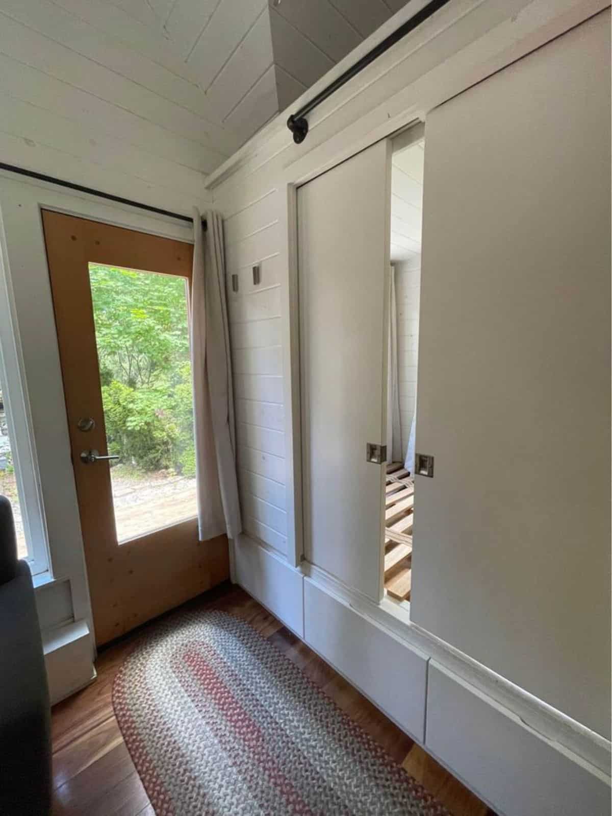 sliding door of main floor bedroom and main entrance glass door of tiny home with lot