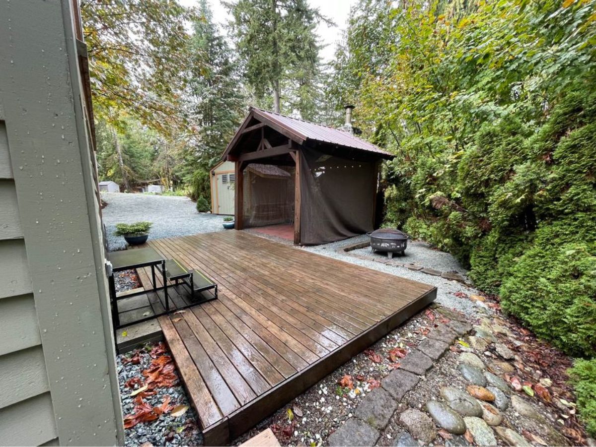 huge porch outside the main entrance of tiny home with lot
