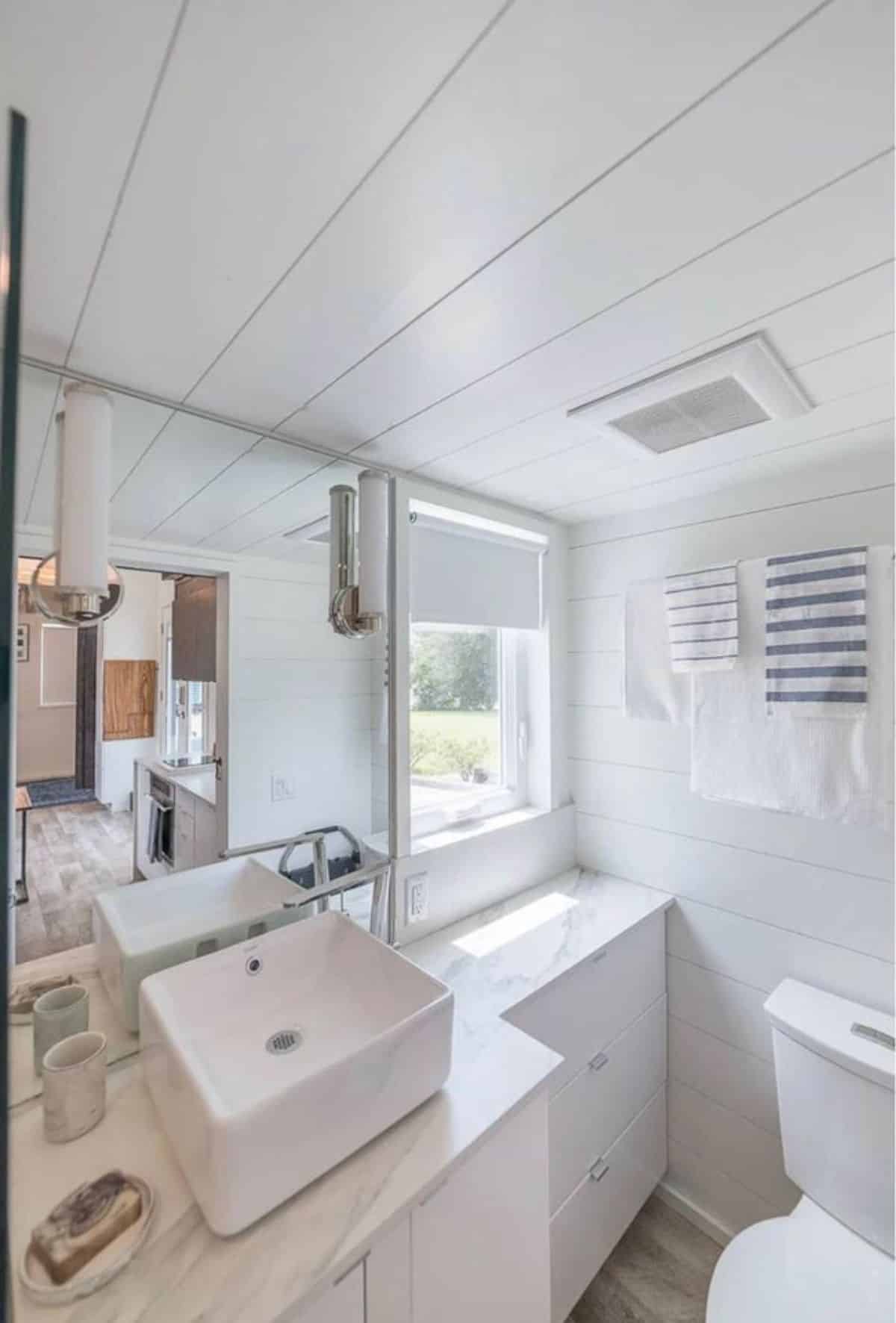 white themed bathroom of tiny house in lakefront community has all the standard fittings