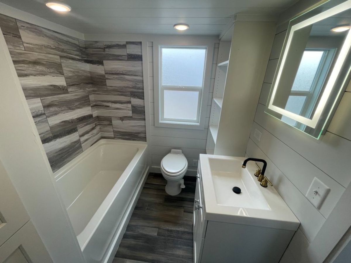 bathroom of tiny RV home has all the standard fittings with a bath tub