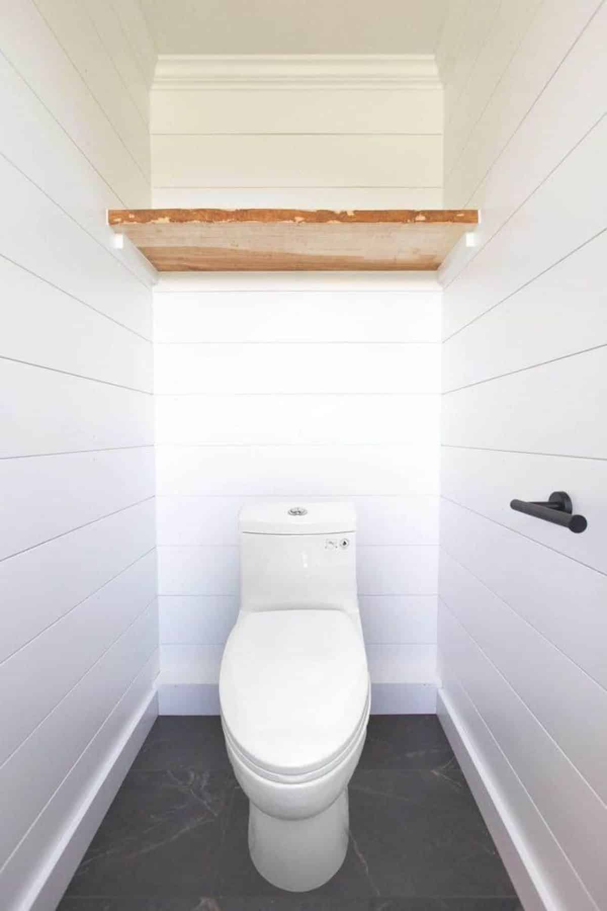 Standard toilet in bathroom of one bedroom tiny home
