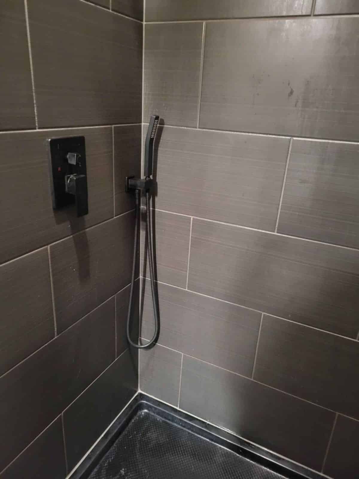 shower area is stunning with black tiled