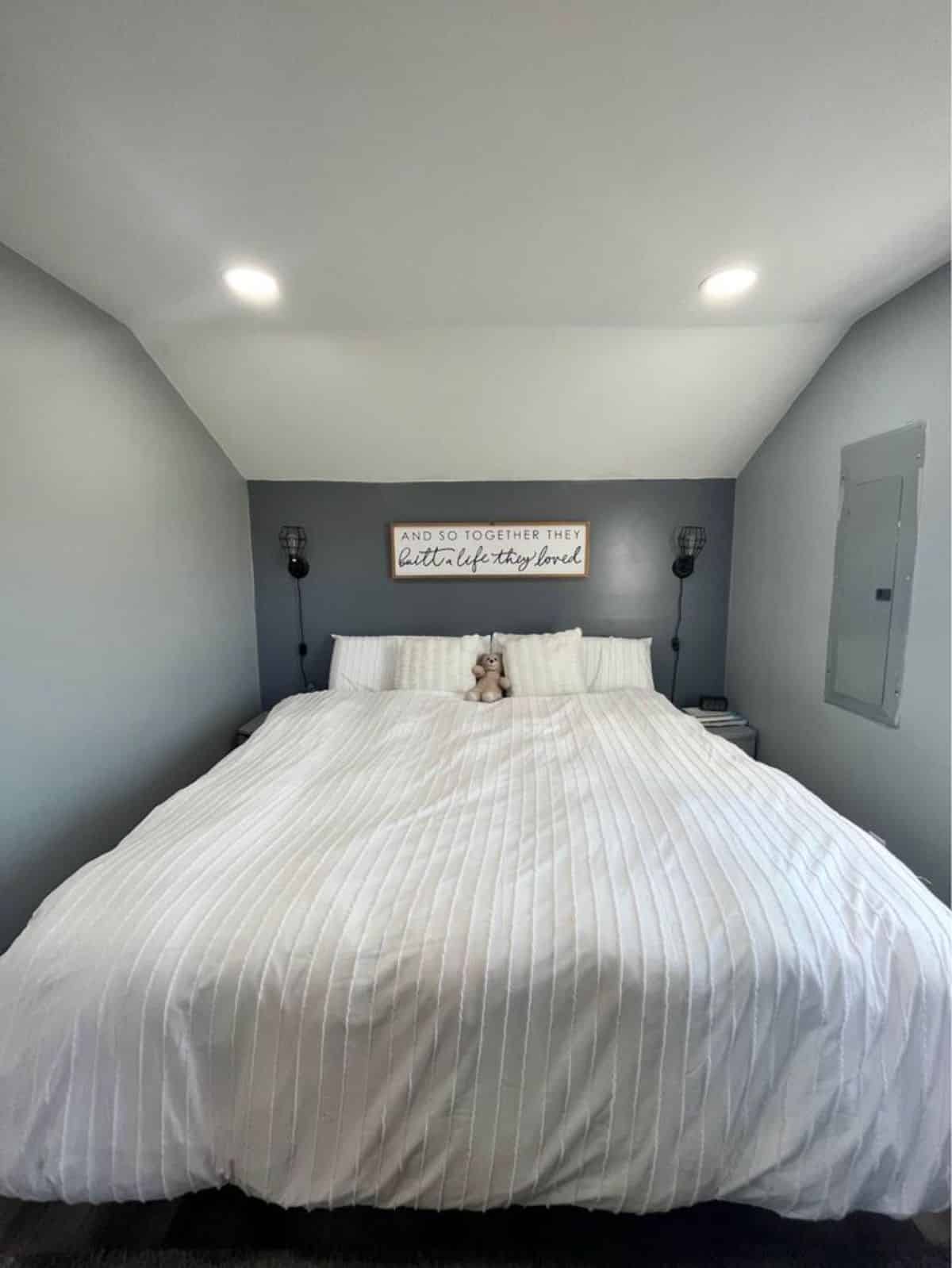 bedroom of tiny house has a comfortable king size bed with ample space left