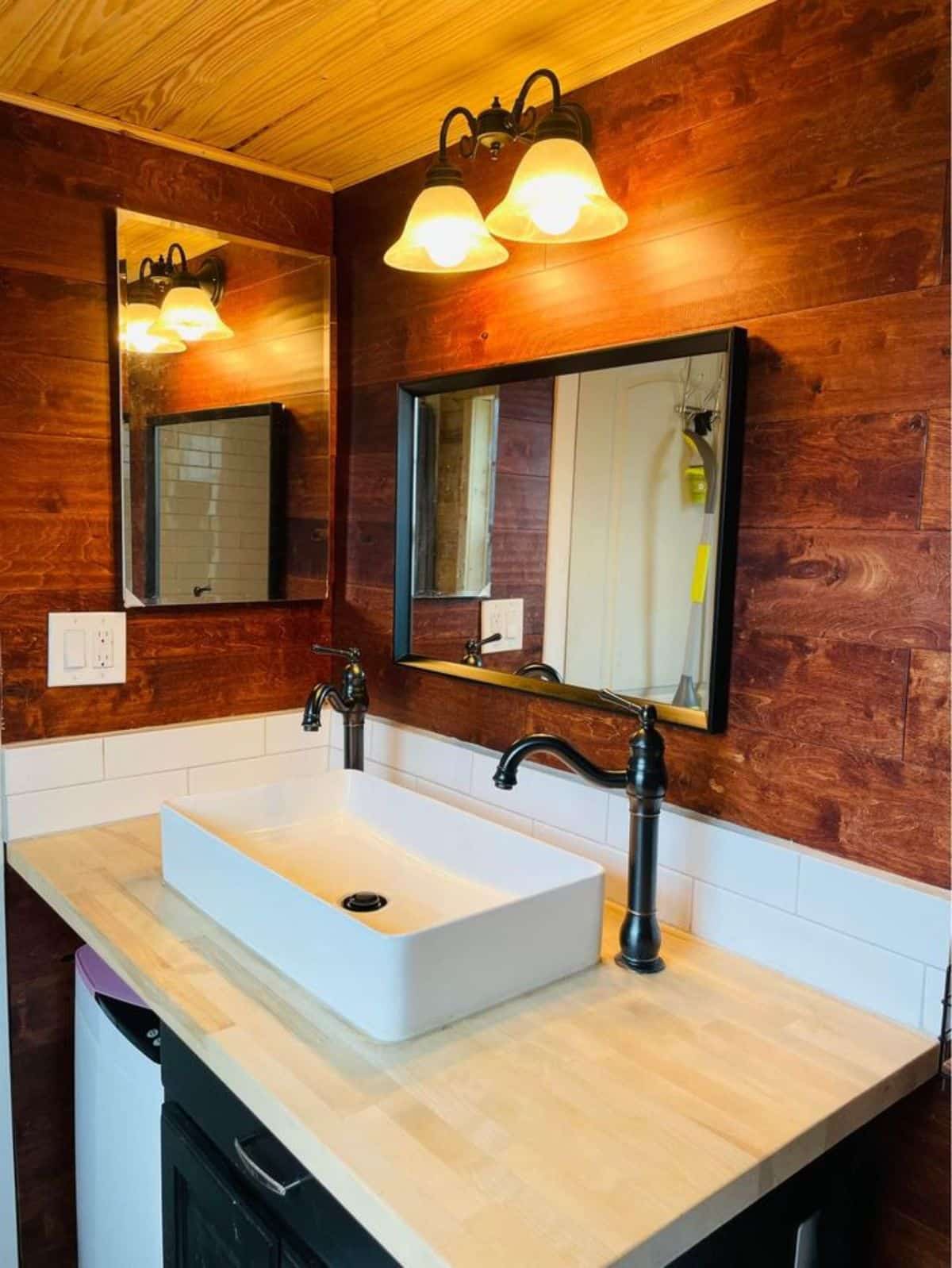 standard toilet, sink with vanity and mirror in bathroom