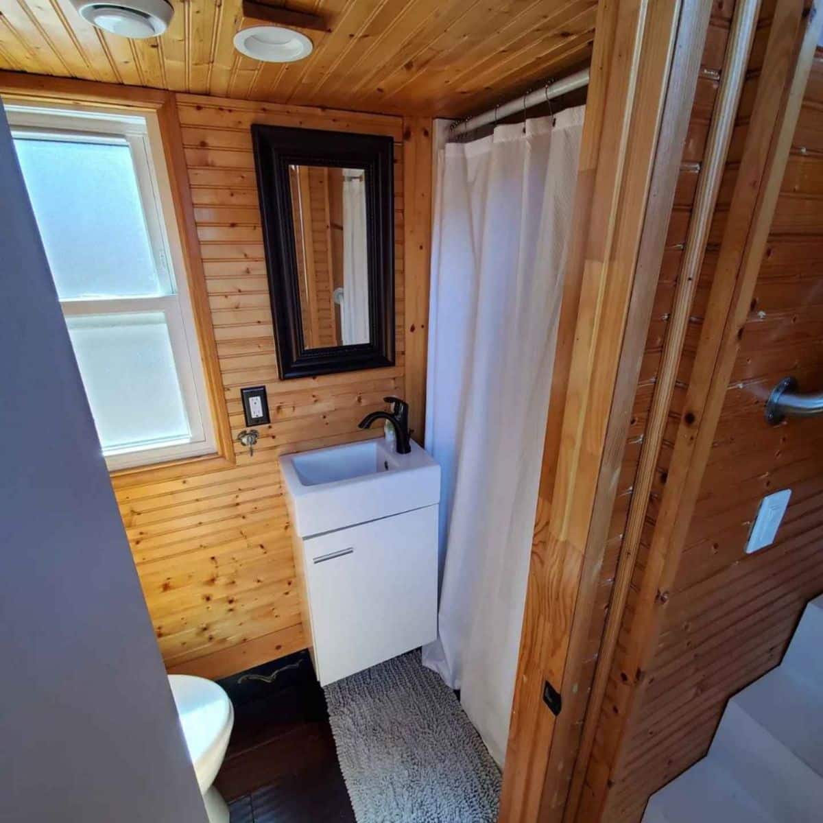 bathroom of tiny home with downstairs bedroom has all the standard fittings