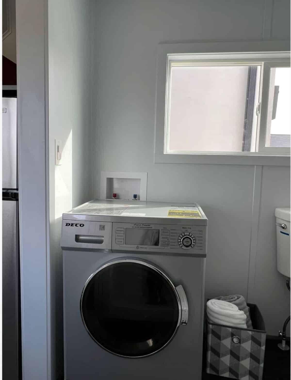 washer dryer combo in bathroom of 20’ modern tiny home