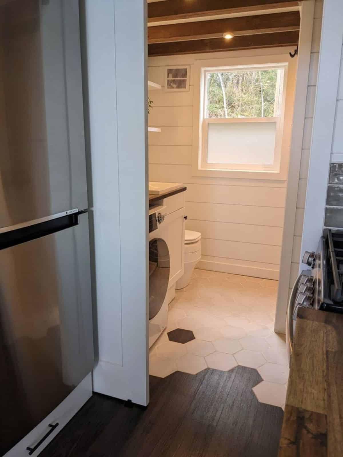 double door refrigerator in kitchen on the entrance way of bathroom