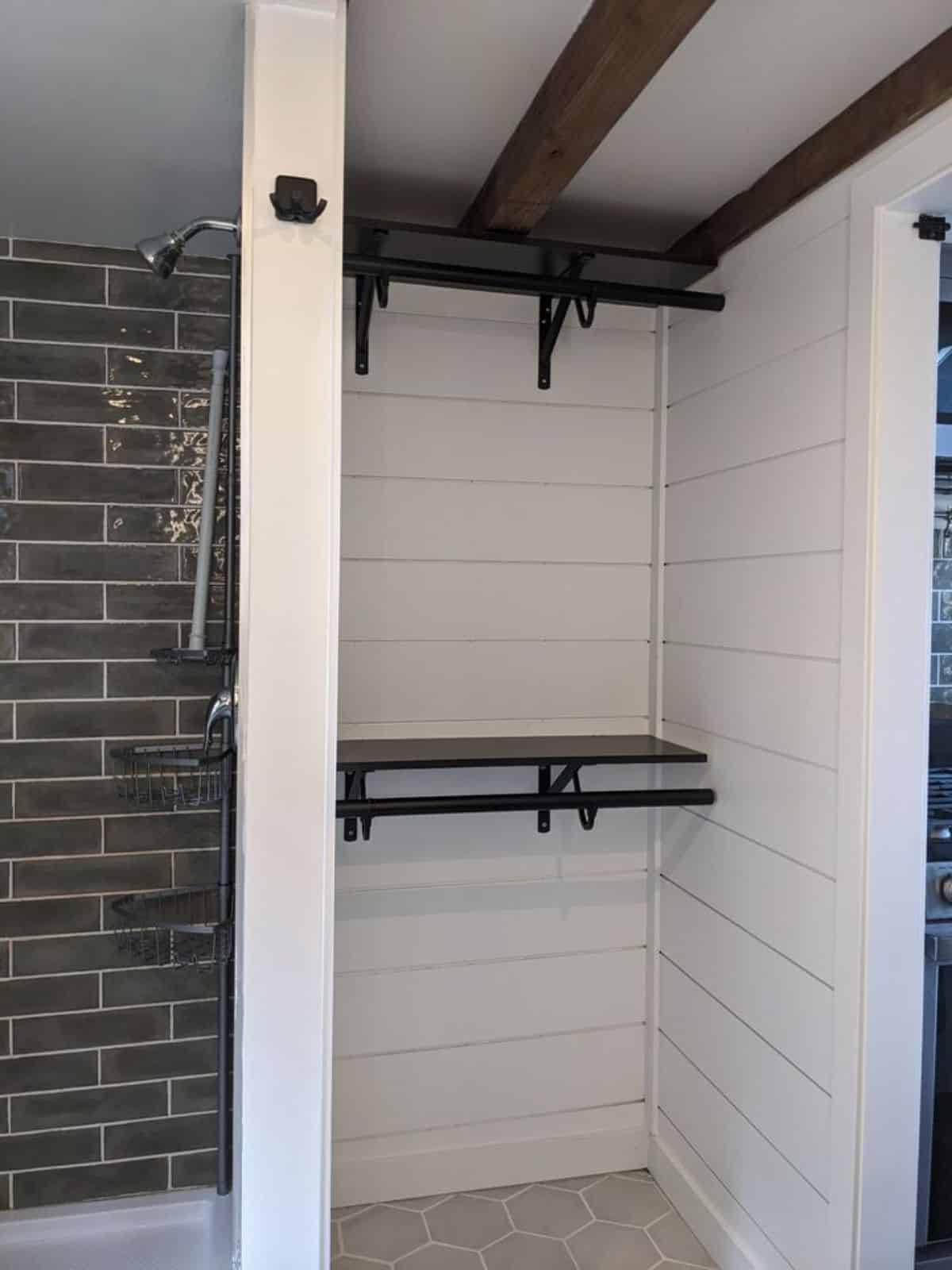 full size standing closet right at the entrance of the bathroom of 24’ tiny house in Canada