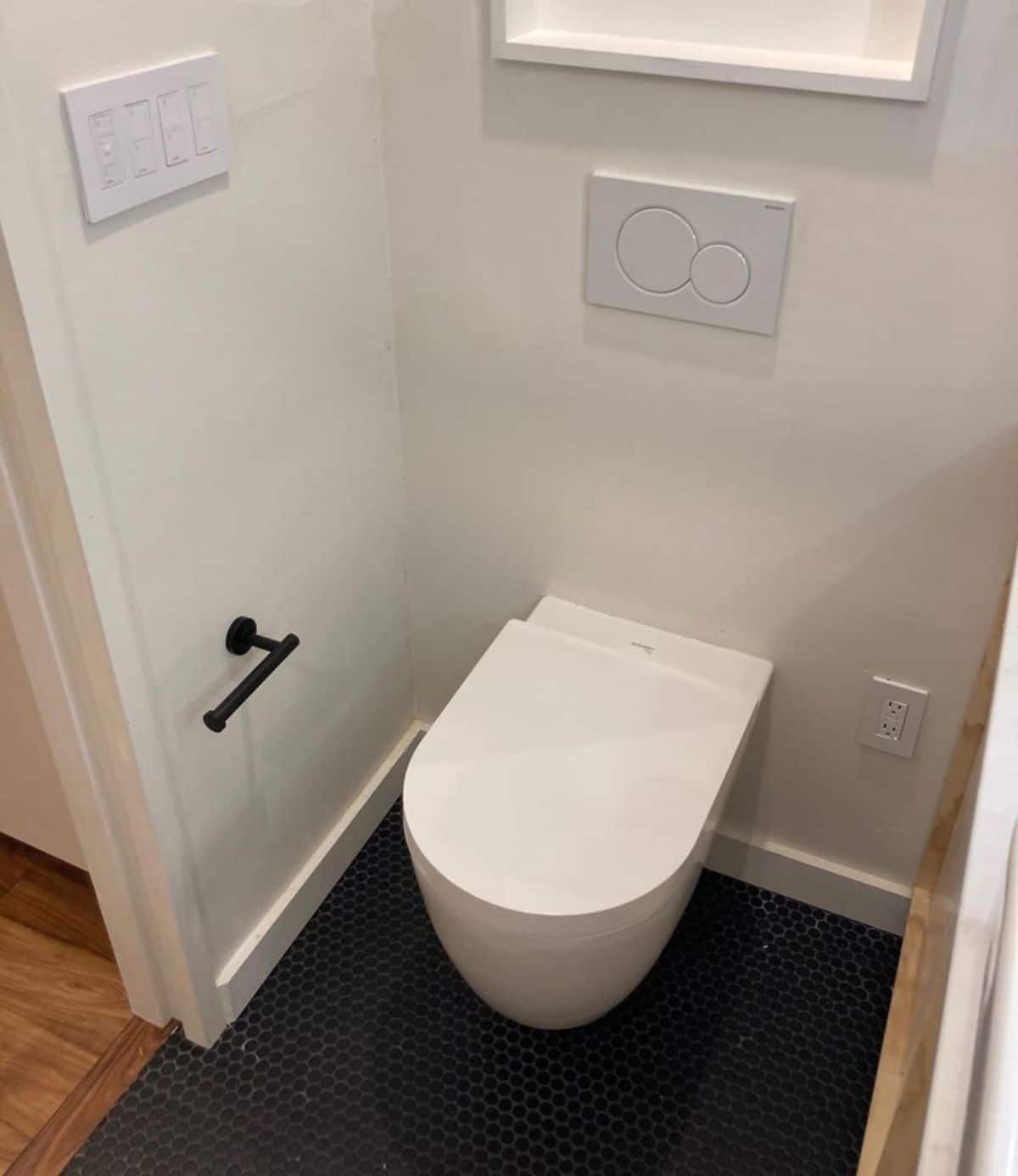 standard toilet in bathroom of 27’ tiny house in Dallas