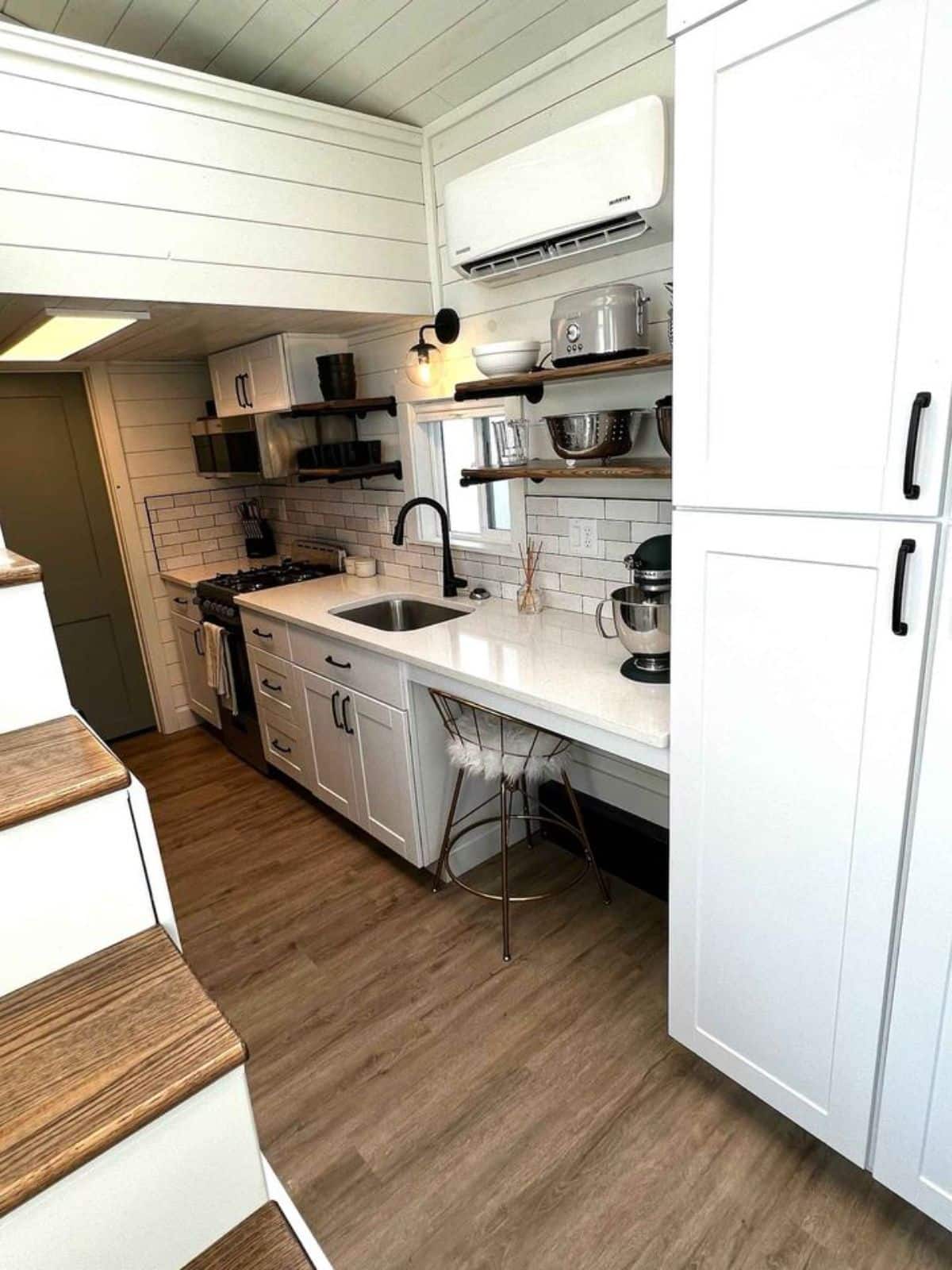one side of the kitchen has a countertop, stove cum oven and storage with a huge pantry cabinet