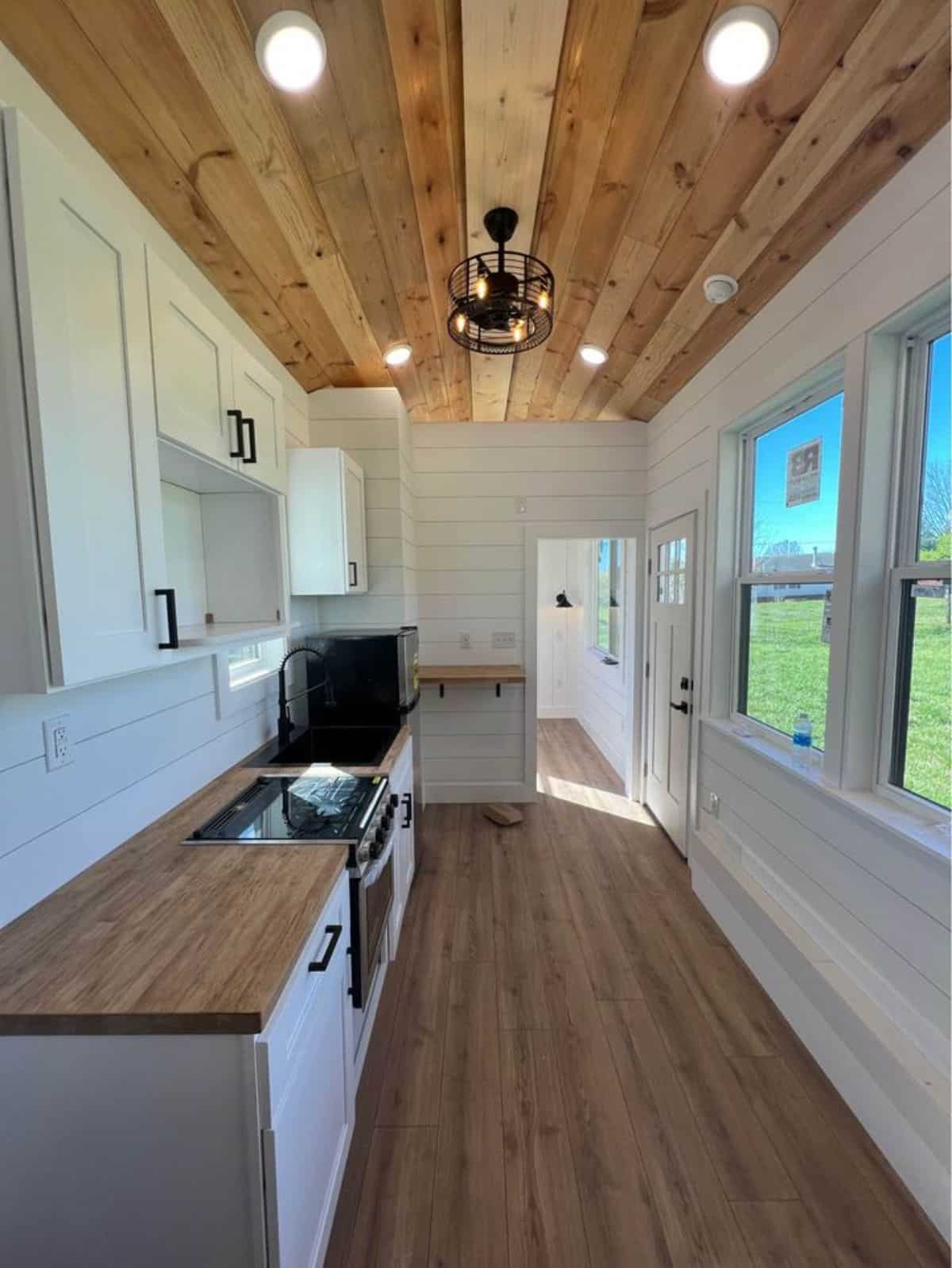 beautiful chandelier, led lights and huge windows all over the 28’ tiny farmhouse