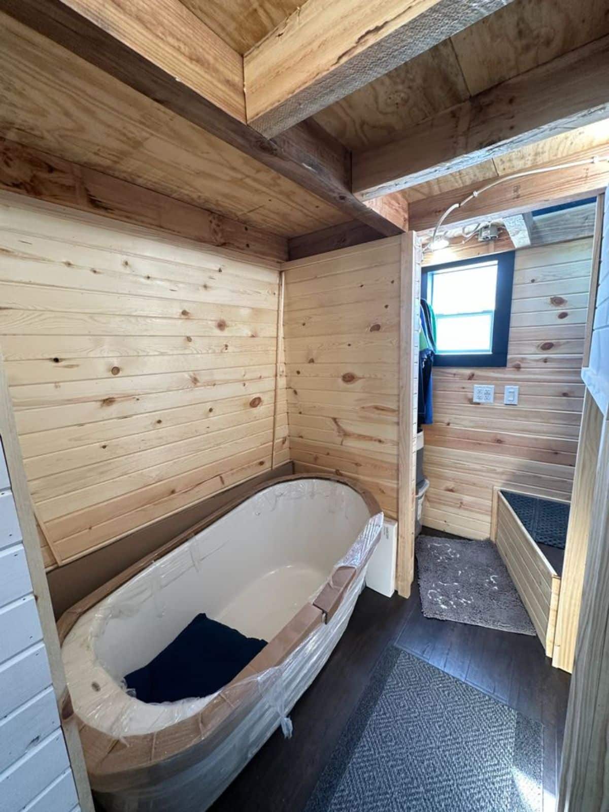 bathtub opposite to composting toilet of 32' fully furnished tiny home