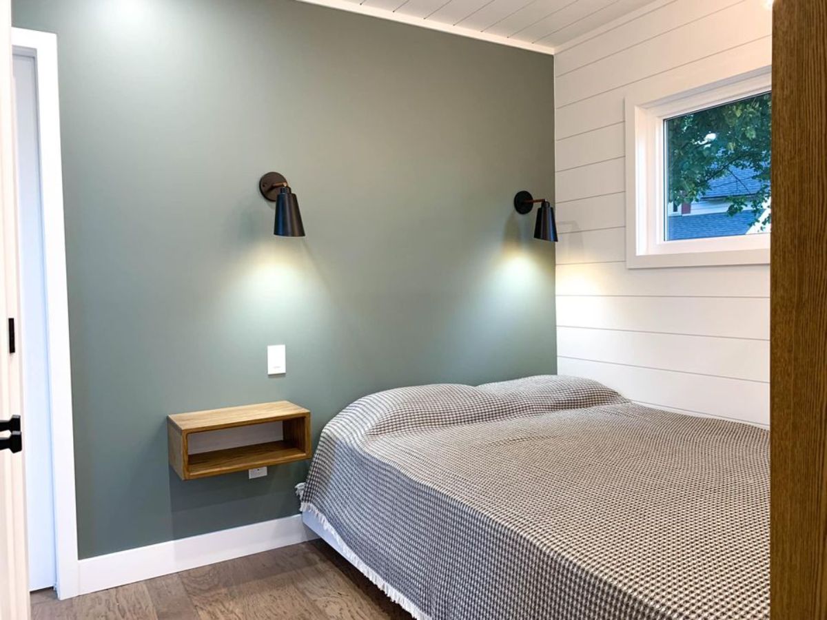 bedroom of tiny house is comfortable with huge bed, still ample space left