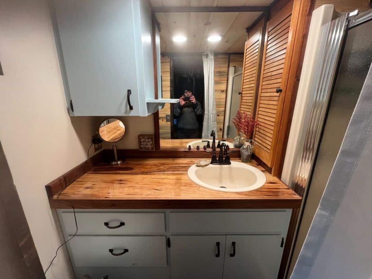 sink with vanity and mirror in bathroom of 40' beautiful tiny home