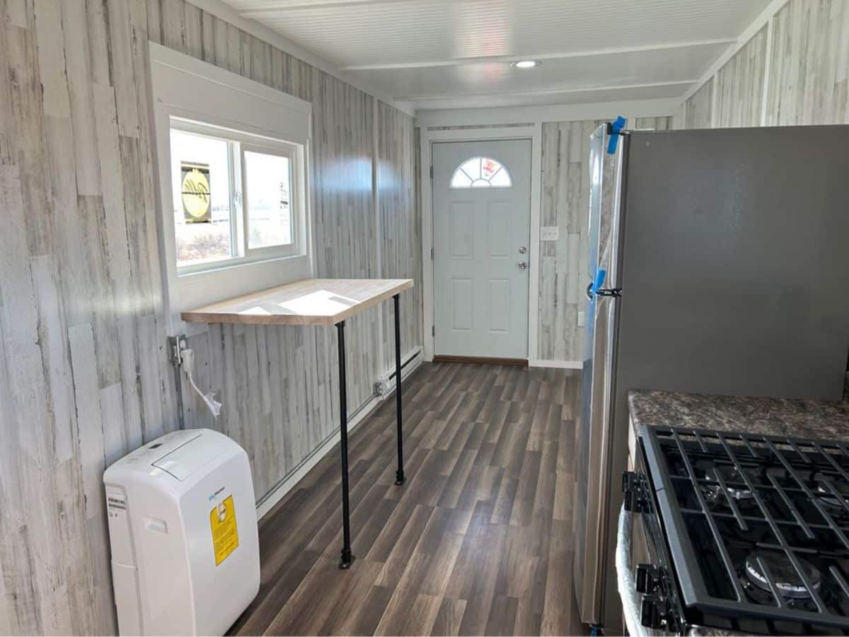 wooden interiors of 45’ spacious tiny home from kitchen view