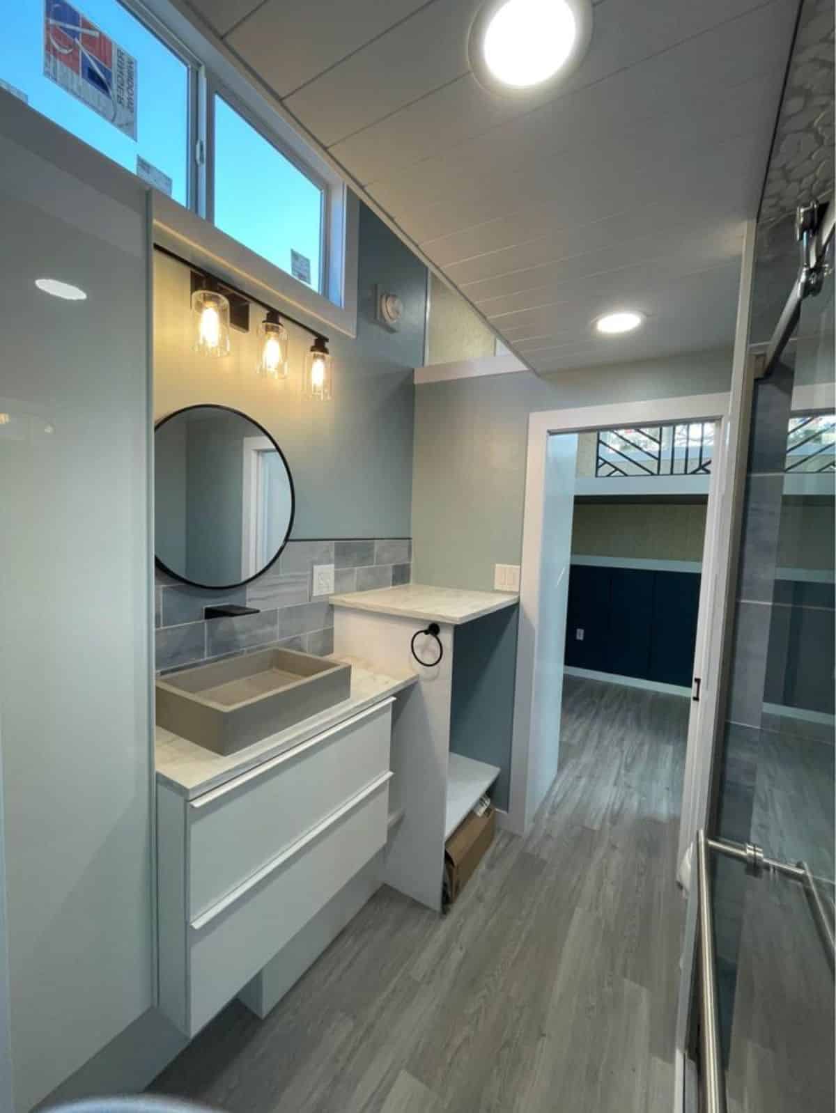 sink with vanity and mirror  & separate space for washer dryer combo in bathroom